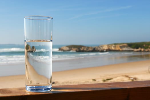 water in glass with view on ocean