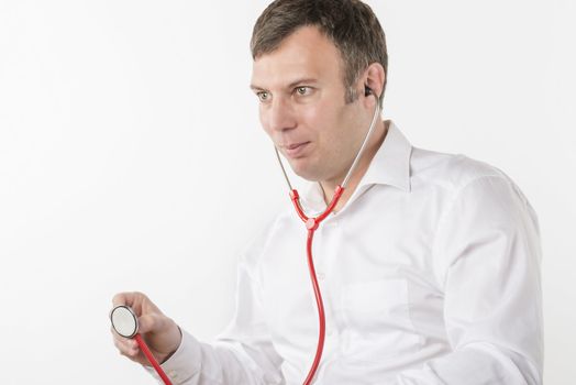 Man in white shirt is holding a red stetoscope on white background