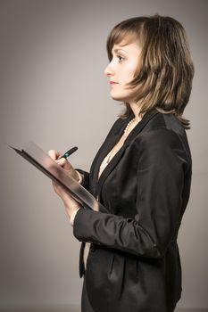 Business woman in black suit takes notes with a pen in a file