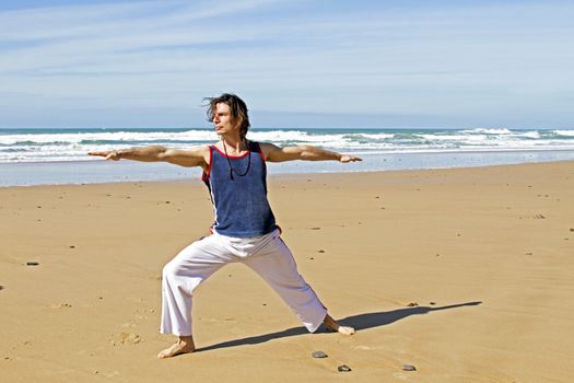 Man doing yoga exercises at the beach