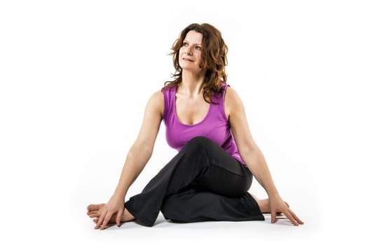 Brunette woman is doing a stretching exercise on white background