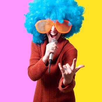 beautiful girl with curly blue wig and turtleneck on colorful background