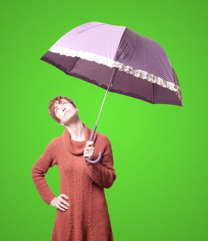 beautiful woman with sweater and umbrella on green background