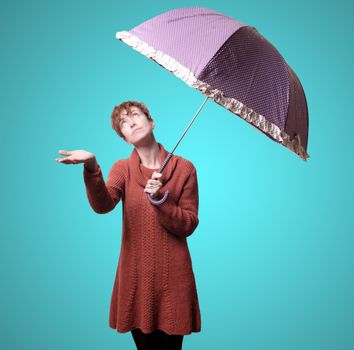 beautiful woman with sweater and umbrella on blue background