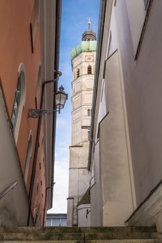 Narrow alley with stairs and look at a church in the town of Dachau, Germany