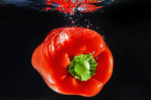 One red pepper under water with bubbles