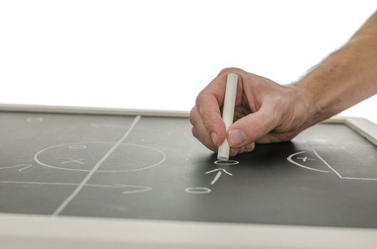 Side view of a hand writing a soccer game strategy on a blackboard. Over white background.