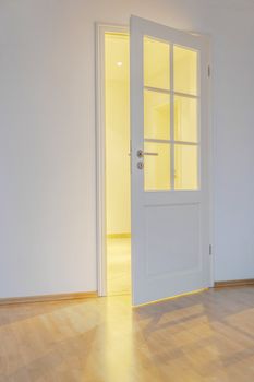 room with parquet floor, open door and light shining