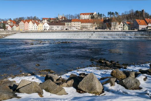 View to a small town in Germany in winter with river and stones in the foreground