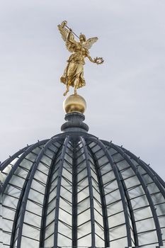 Golden angel with trumpet on the top of historic house in Dresden