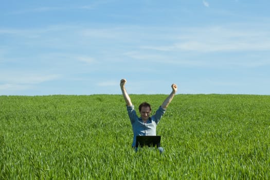 young man using laptop in the field