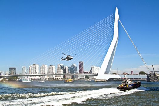 ROTTERDAM, NETHERLANDS - SEPTEMBER 09: Army helicopter is flying in front of the erasmus bridge during the world harbor days on 9 september 2012 Rotterdam the Netherlands