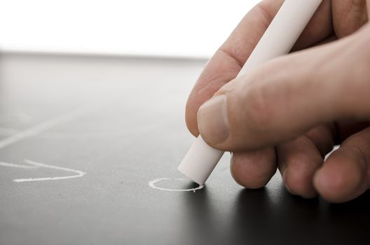 Detail of a coach hand writing a football game strategy on a board.