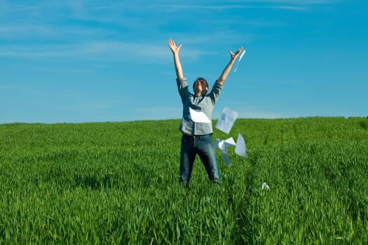 young man throwing a paper in the green field