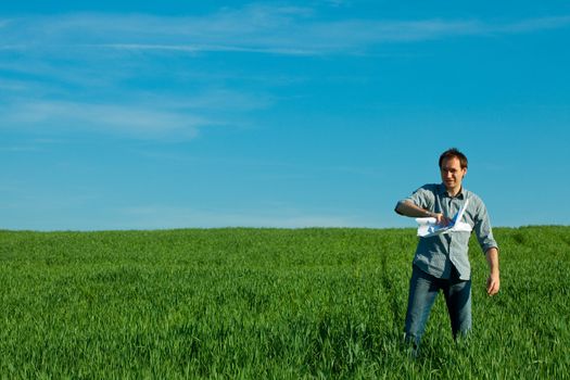 young man throwing a paper in the green field