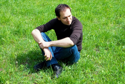 man sitting on green grass