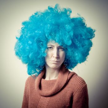 beautiful girl with curly blue wig and turtleneck on white background