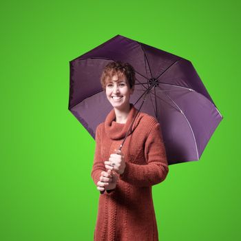 beautiful woman with sweater and umbrella on green background