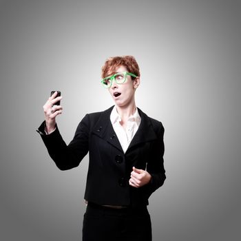 surprised business woman with phone on gray background