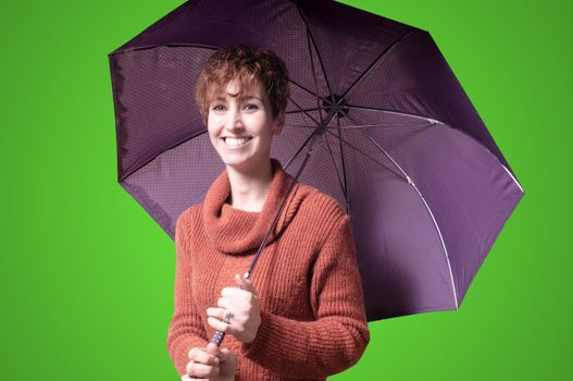 beautiful woman with sweater and umbrella on green background