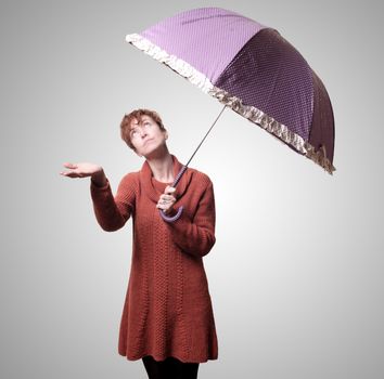 beautiful woman with sweater and umbrella on gray background