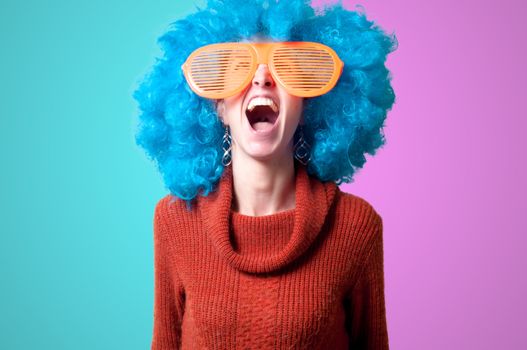 beautiful girl with curly blue wig and turtleneck on colorful background