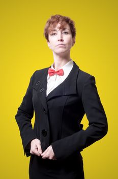 elegant businesswoman with bow tie on yellow background