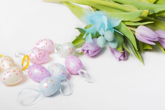Easter eggs with tulips on light background