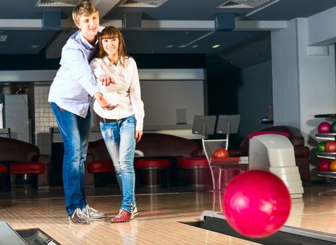 guy hugs her friendgirl, playing together in bowling