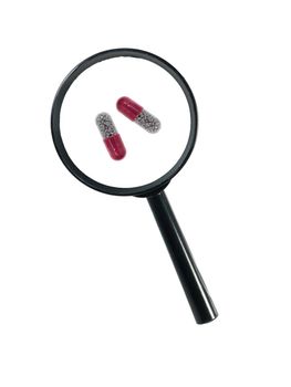 A magnifying glass magnnifying pills on a white background