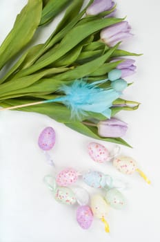 Easter eggs and tulip bouquet on light background