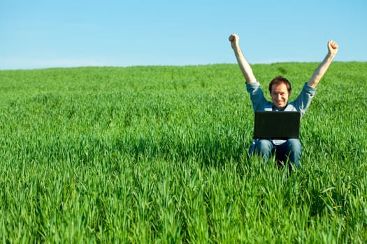 young man using laptop in the field