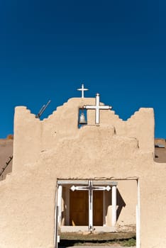 Old Mission church with three crosses and a bell