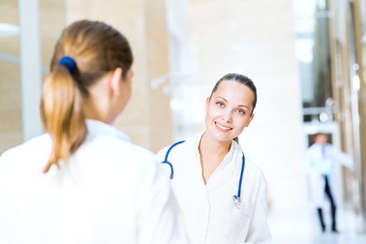 two doctors talking in the lobby of the hospital, sitting on the couch