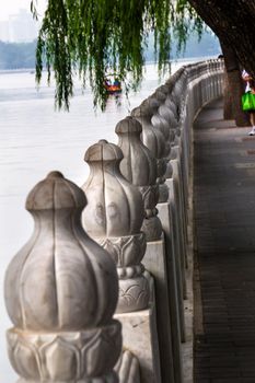 Stone Pillars Walkway Boat Houhai Lake Beijing, China.  Houhai Lake is the old swimming hole in Beijing and is now surrounded by bars and restaurants.