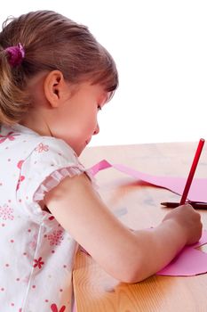 Cute little girl drawing on a pink heart