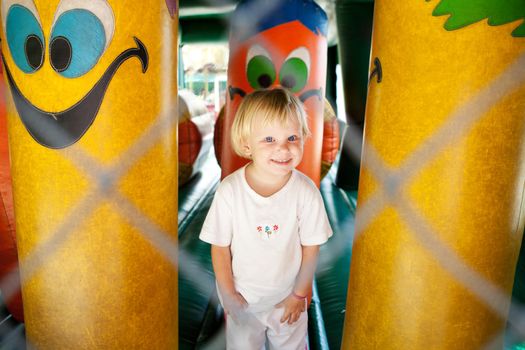 child in the amusement park at trampoline