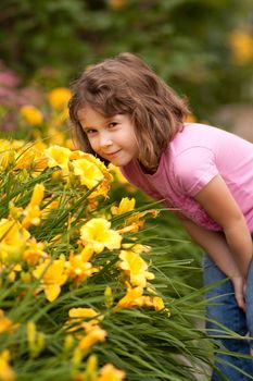 Cute little boy smelling yellow flowers