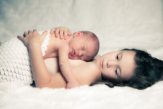 Newborn baby boy resting on his sister