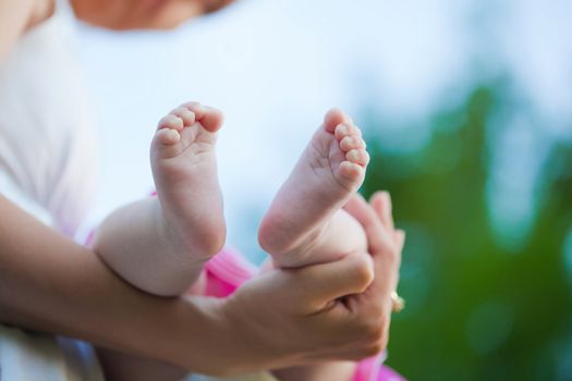Mother holding a baby girl foot in her hand