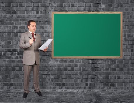 businessman with paper and blackboard on wall
