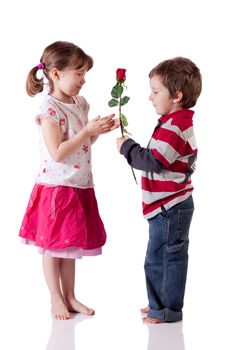 Cute little boy giving a rose to a girl