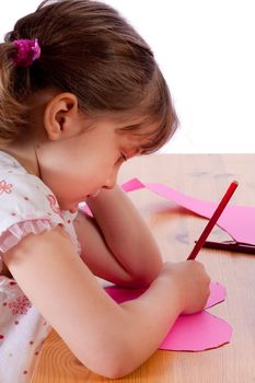 Cute little girl drawing on a pink heart
