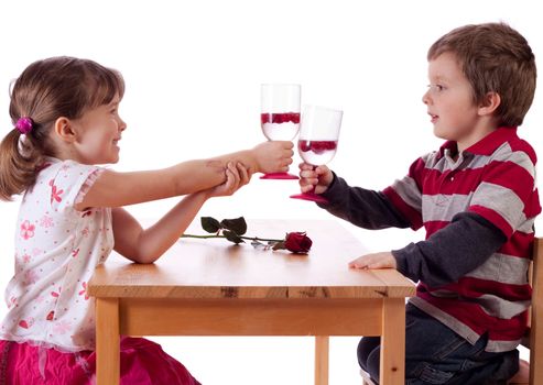 Cute little children making a toast above a red rose