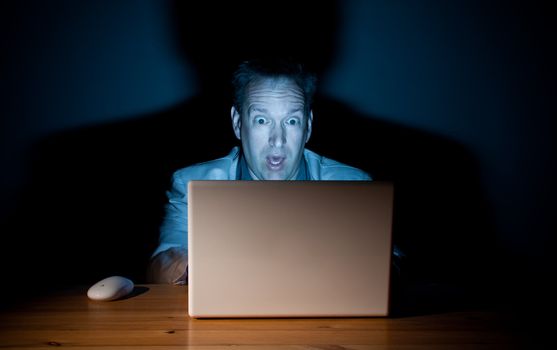 Man looking surprised in front of his computer