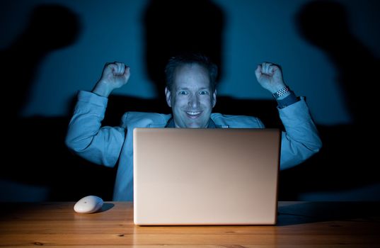 Happy computer guy celebrating late at night