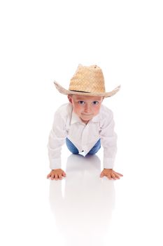 Little boy with a hat doing push-ups