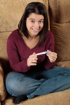 Happy woman holding a positive pregnancy test