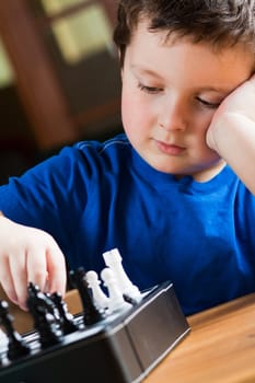Cute little boy playing chess