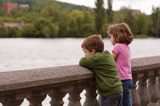 Cute little brother and sister looking at the river